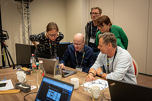 Menschen arbeiten konzentriert an Laptops in einem modernen Büro.