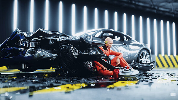 A crashdummy in an orange suit sits on the ground next to a wrecked car.