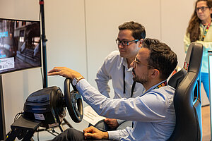 Zwei Männer fahren in einem Auto-Simulator.