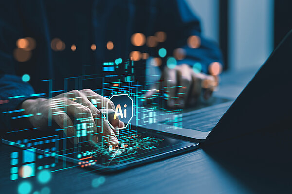 A person is working on a laptop with a digital user interface.