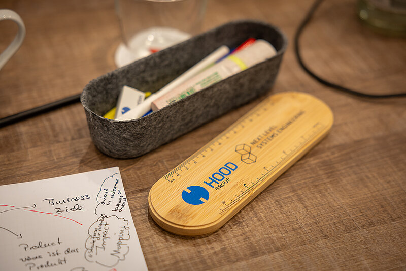 A wooden table with a pen and a pencil on it.